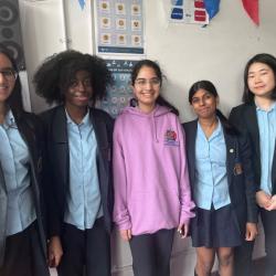 Five teenage girls in school uniform smiling at the camera