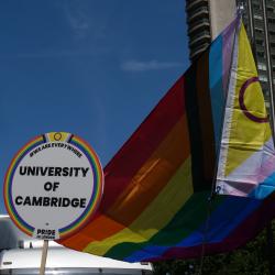 University of Cambridge placard with rainbow flag backdrop