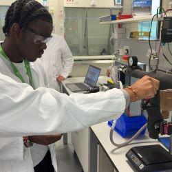 Young man in white lab coat watching chocolate melting process