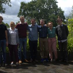 Six newly promoted academic staff with head of department Clemens in front of greenery